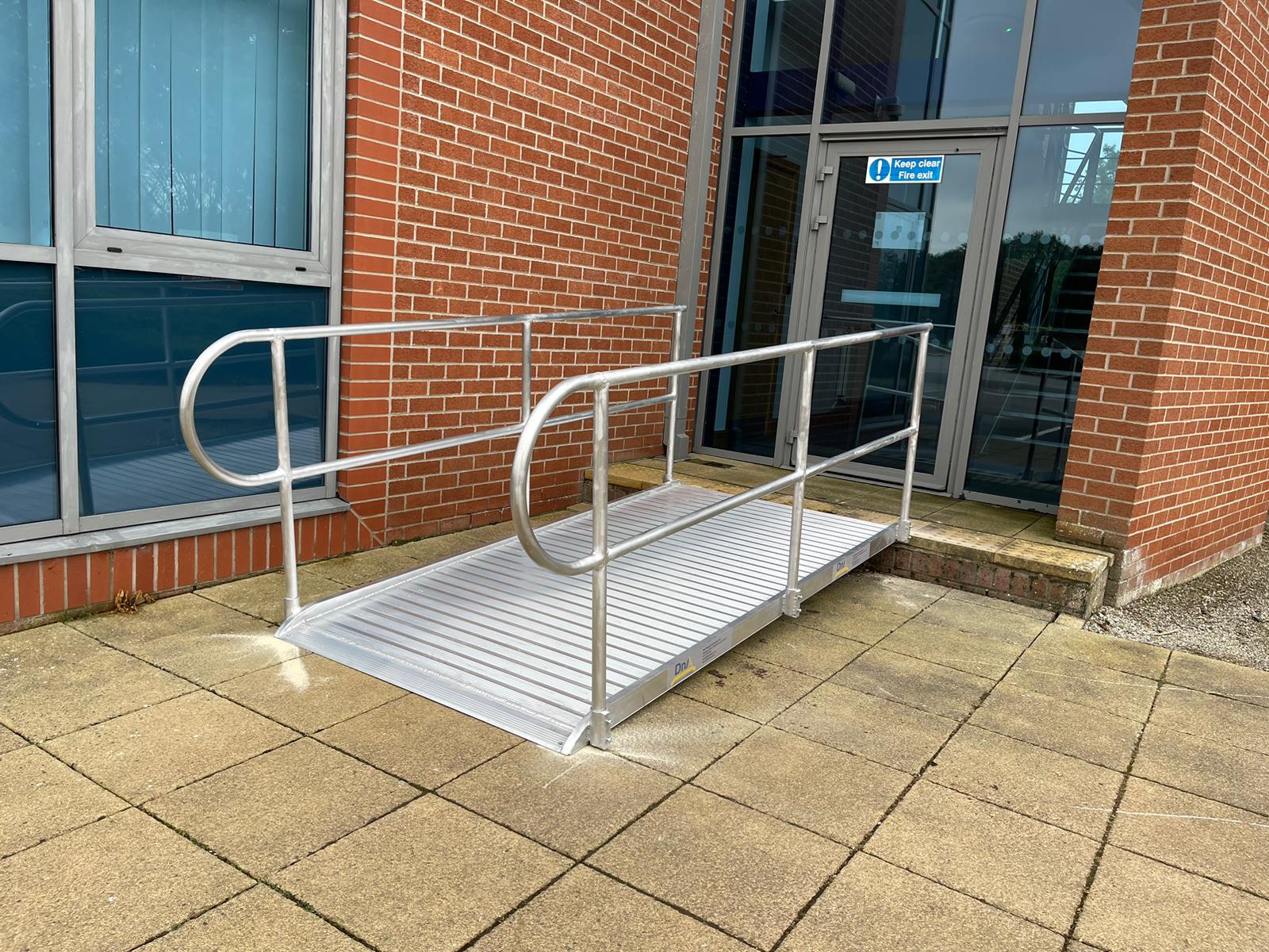 A durable bespoke wheelchair ramp installed over the front steps of a domestic home.
