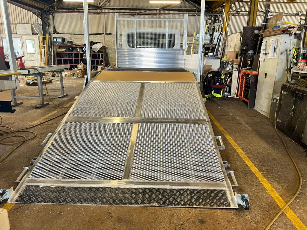 Secure folding van loading ramp attached to the rear of a delivery vehicle.